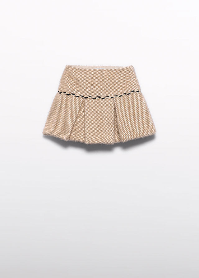 A beige pleated mini skirt with a black dashed contrast trim at the waistband, shown against a plain white background.